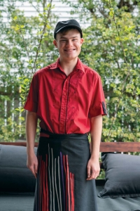 Young man smiling and wearing work uniform.